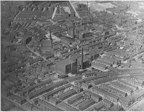 A black and white aerial photograph showing Summervale Mill and the surrounding streets, which are mostly terraced houses with some other industrial buildings.# If there is one